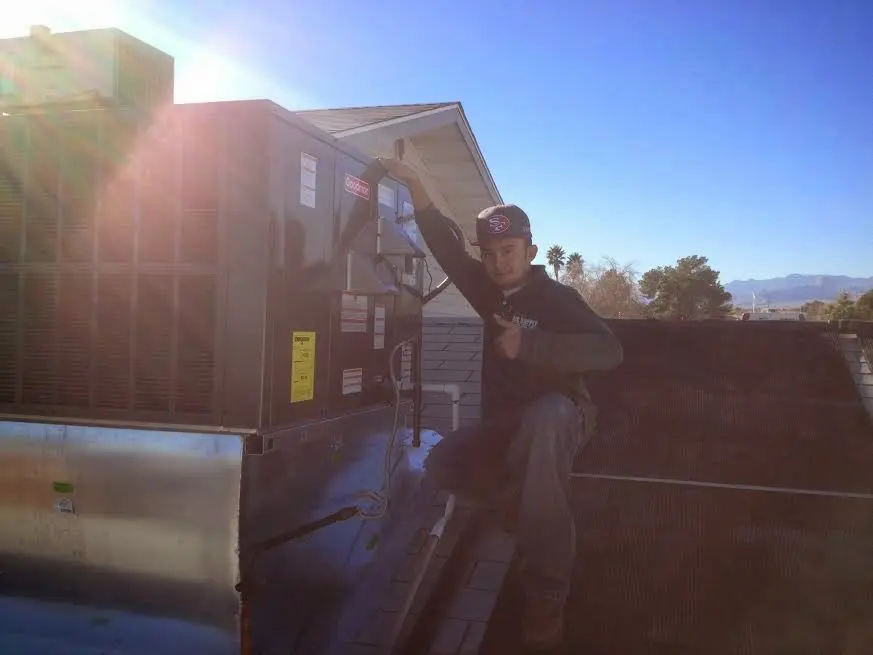 HVAC technician performing Heat Pump Repair on a rooftop unit in Yankee Springs